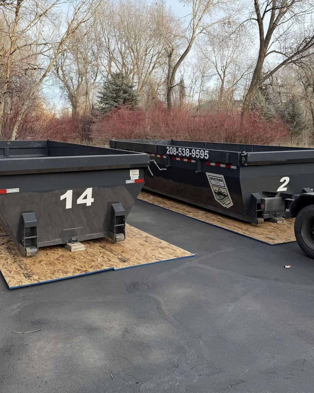 20-yard roll-off dumpsters set on plywood to protect the driveway